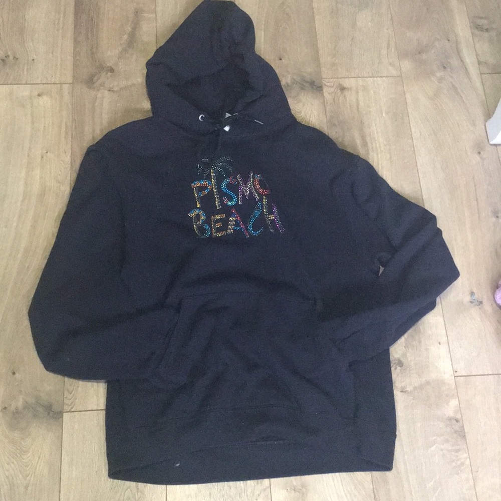 Black hoodie with “Prismo Beach” written in gems